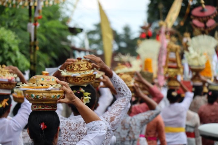 women carrying offering of flowers and food in A local celebration of their gods in Ubud, Bali