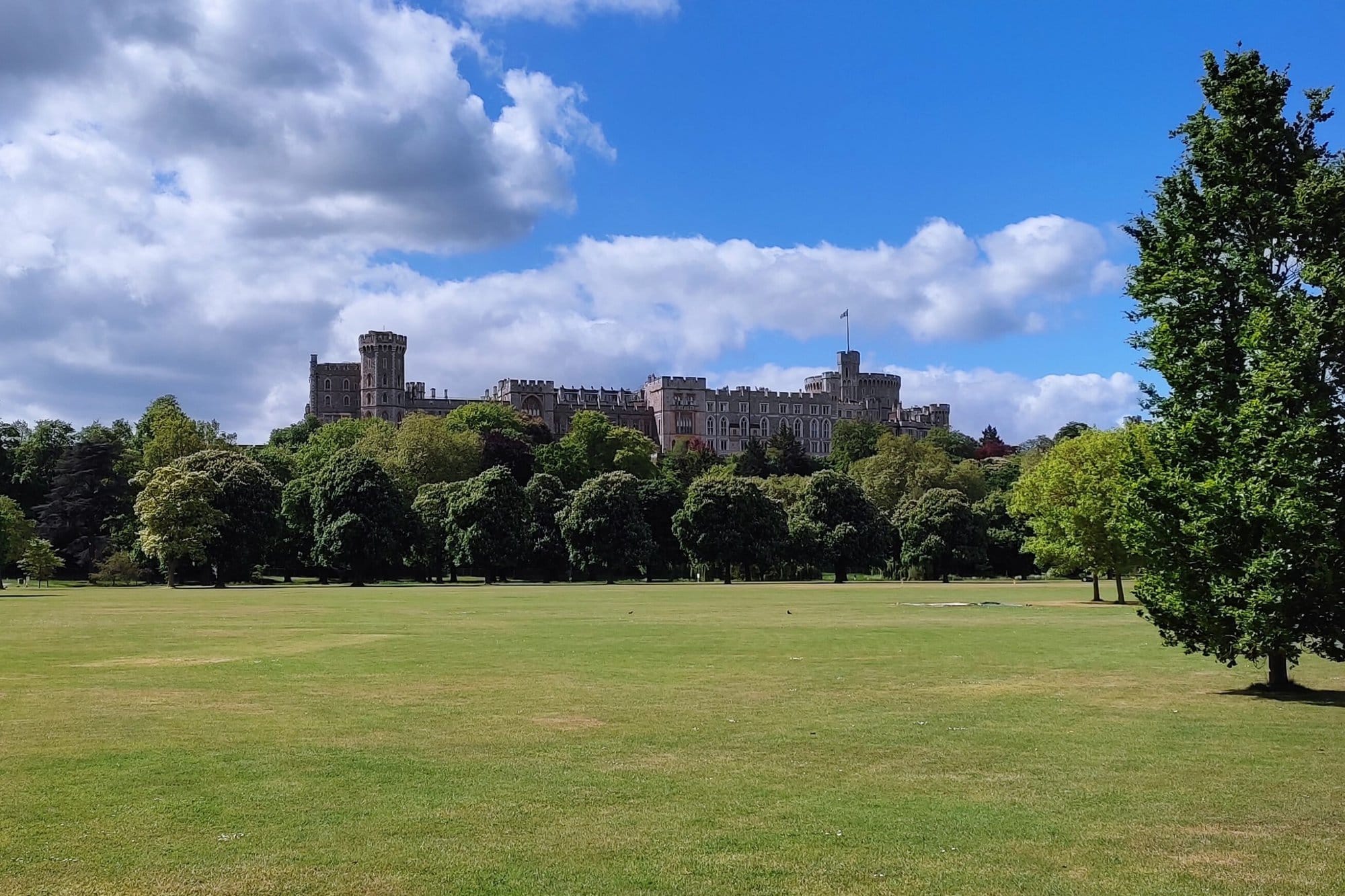 Windsor Castle in the distance beyond a green field