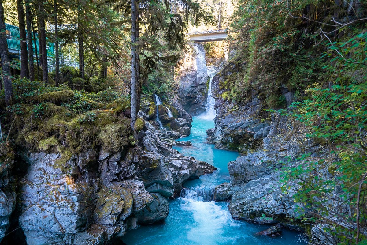 a aqua blue stream running down a rocky creek