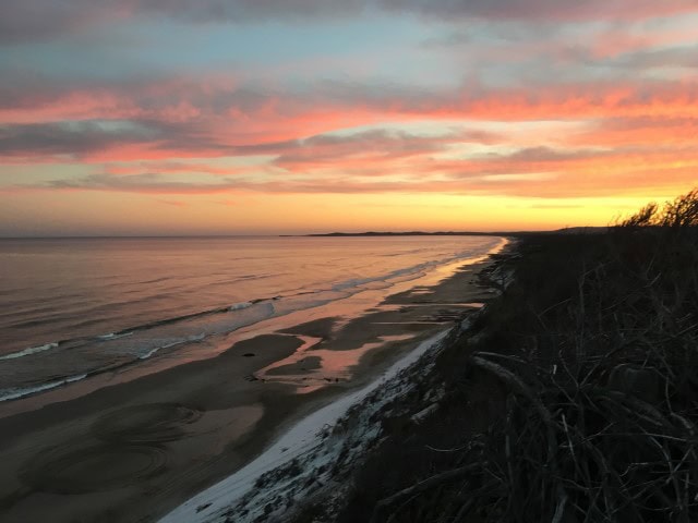 orange glow of sunset along the coastline