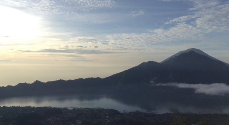 Sunrise views across a misty lake from the top of Mount Batur