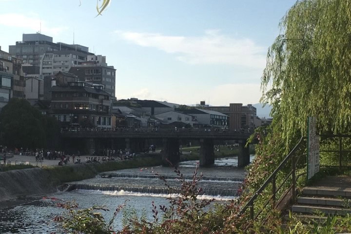 river running through Kyoto with a bridge in the distance