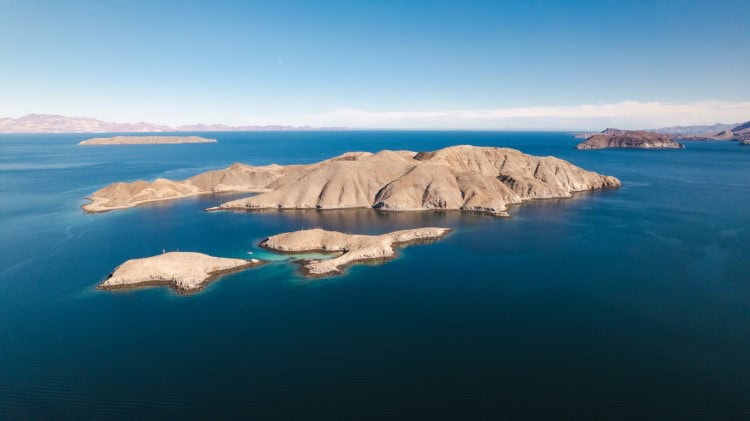 white smooth rock islands in the middle of a blue sea