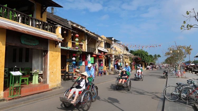 tourists on cyclos in hoi an old town