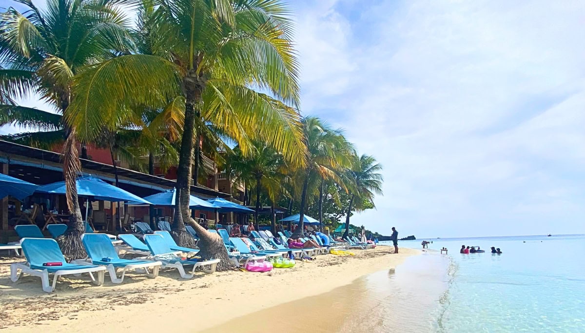 white sand beach with blue umbrellas an beach chairs