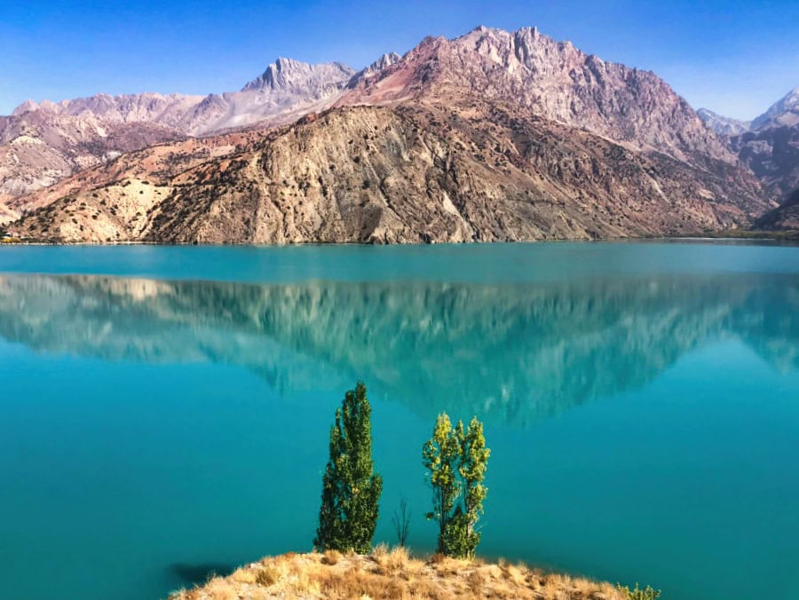 a green coloured lake surrounded by mountains