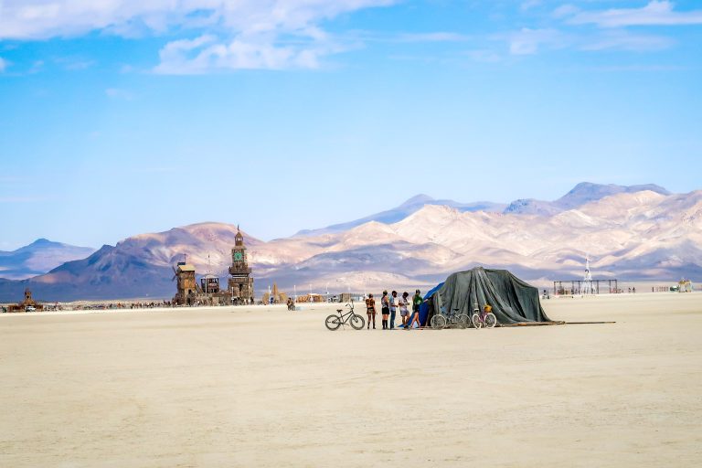 large sculptures and tenets in the distance in the desert
