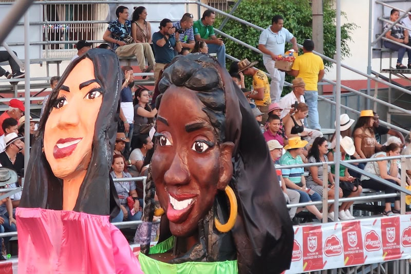 paper mache heads of 2 women in a street parade