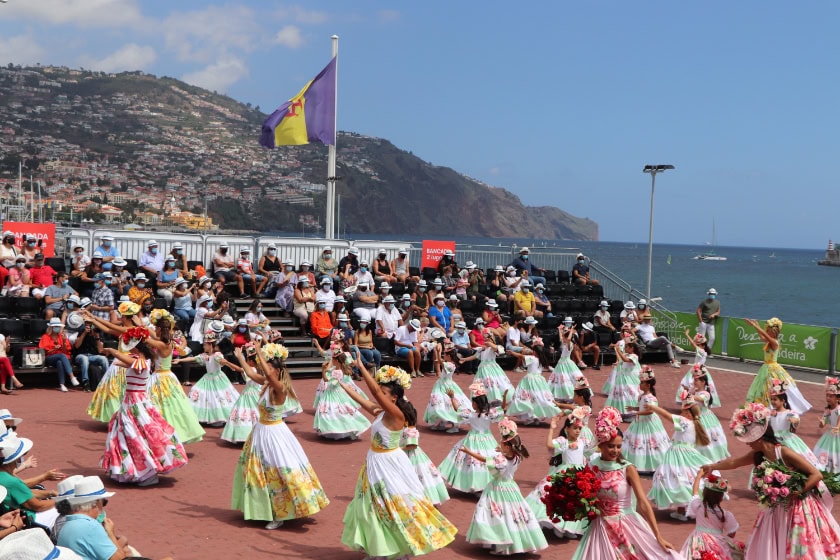 women dressed in traditional costume on a platform overlooking the sea