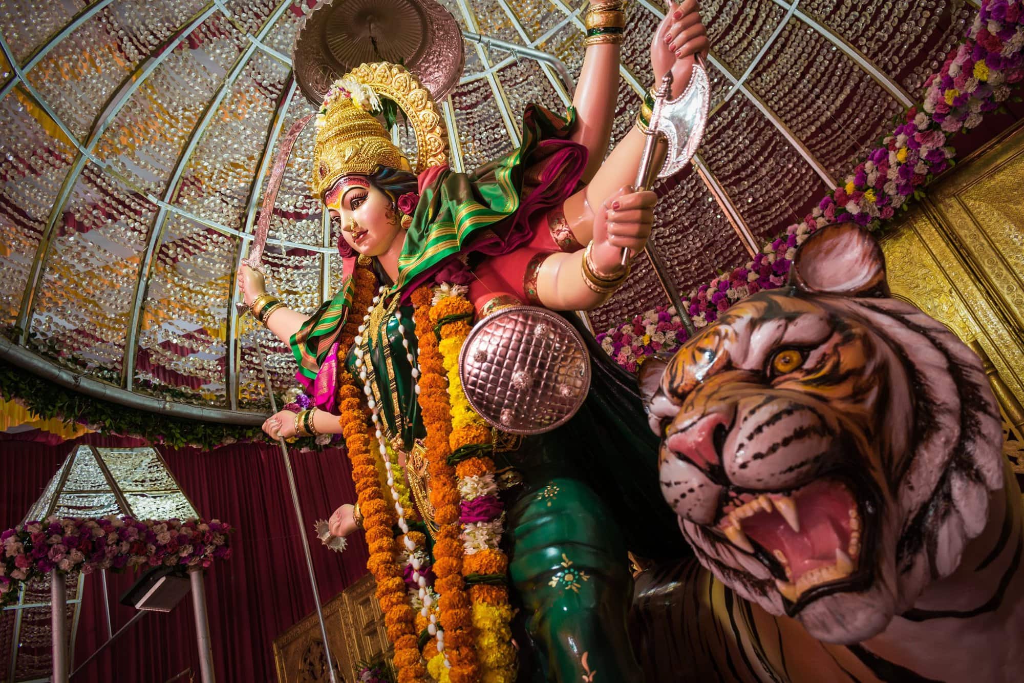 goddess in a temple next to a statue of a lion