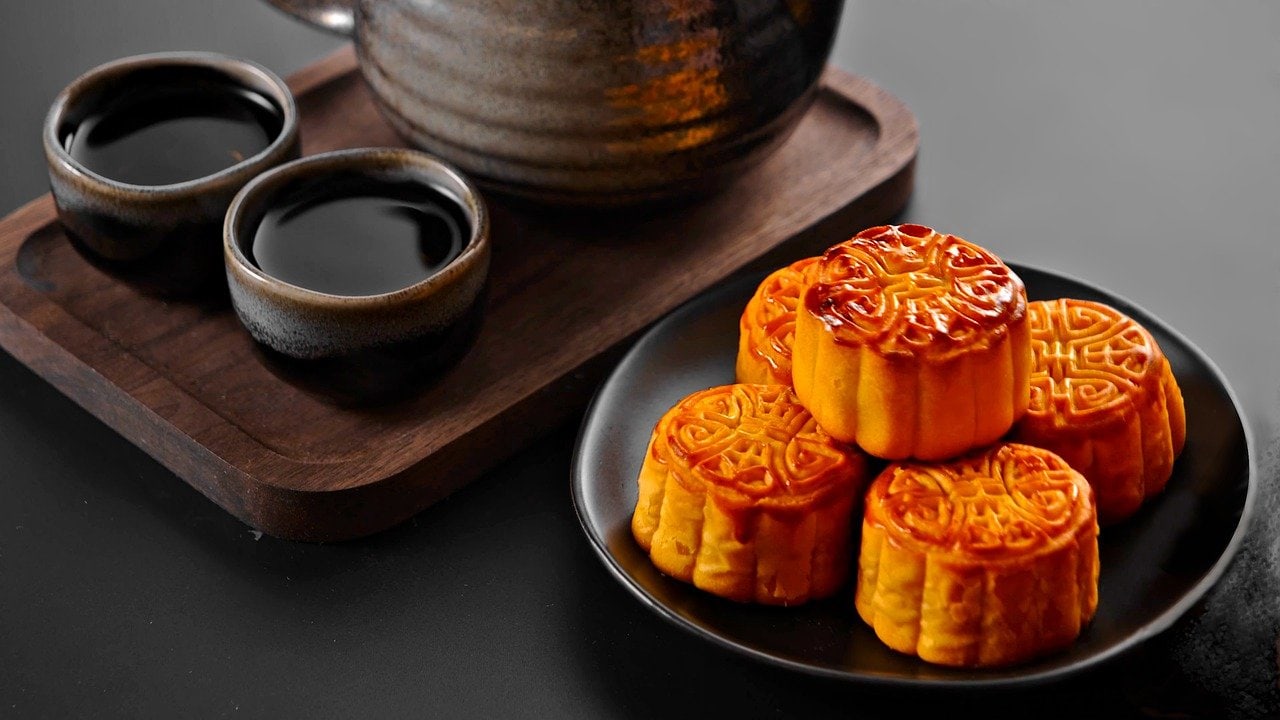 mooncakes on a plate and a pot of tea and mugs