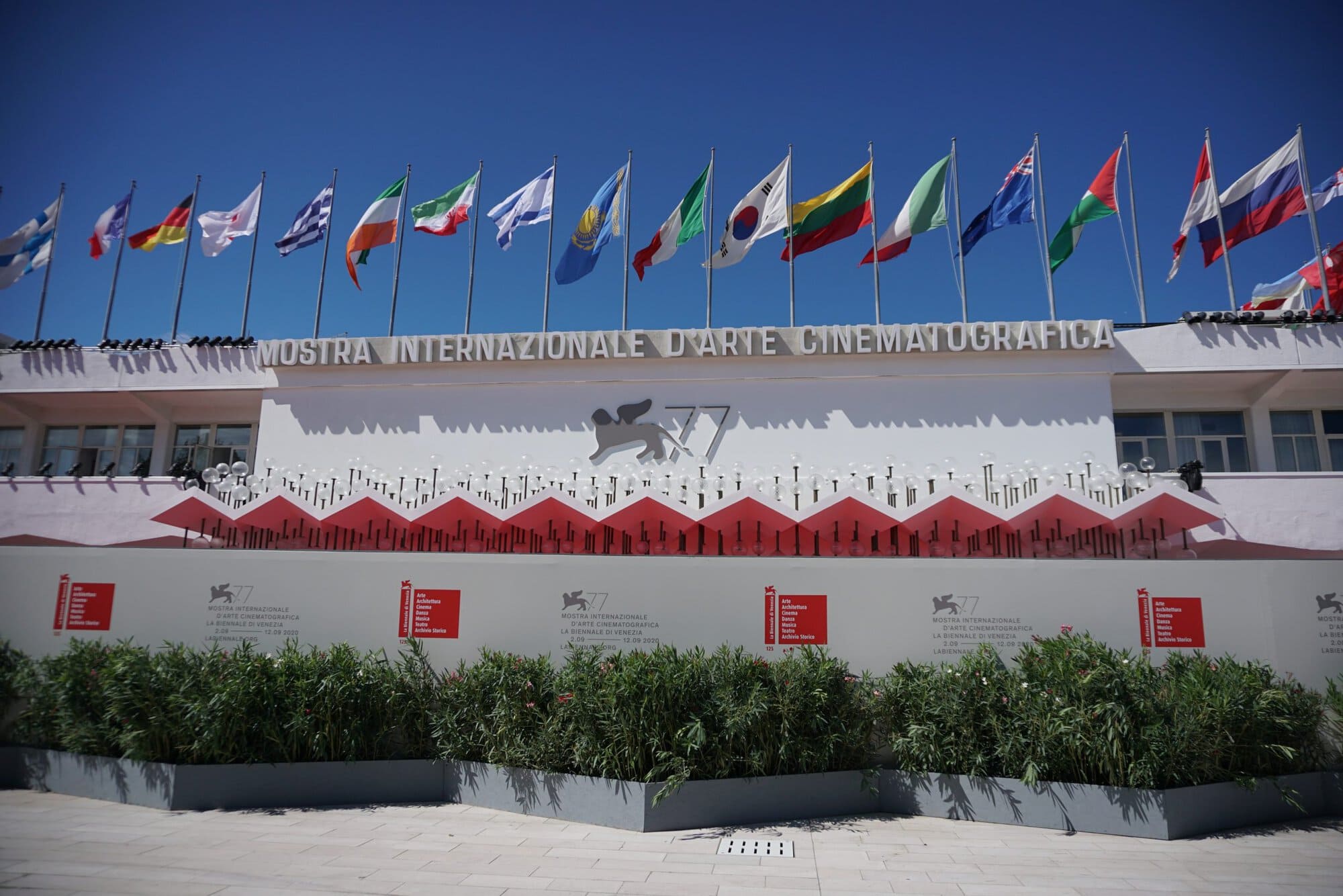the outside of a building with flags along the roof