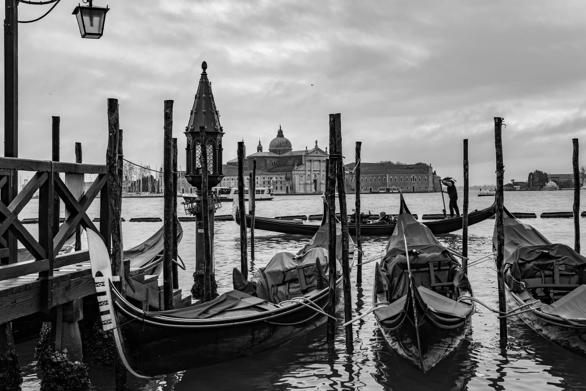 gondolas in the water with buildings in the background