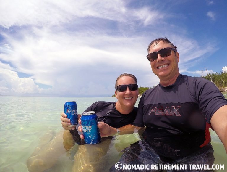 a couple sitting in the water drinking beers