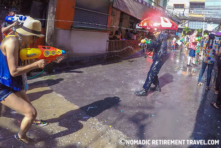 police particiapting in a water fight n the streets during songkran
