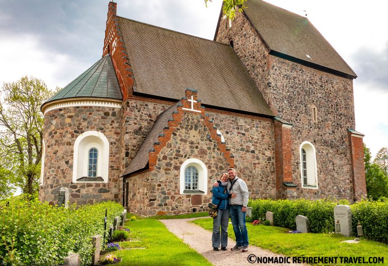 a couple standing in front of a very old church in sweden