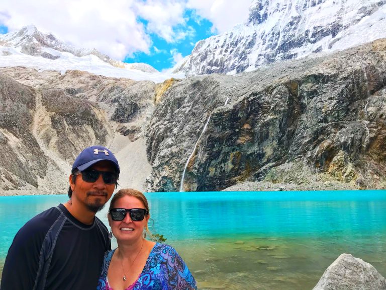 a couple standing in fron of the icy blue waters of Laguna 69 Huascarán National Park, Peru
