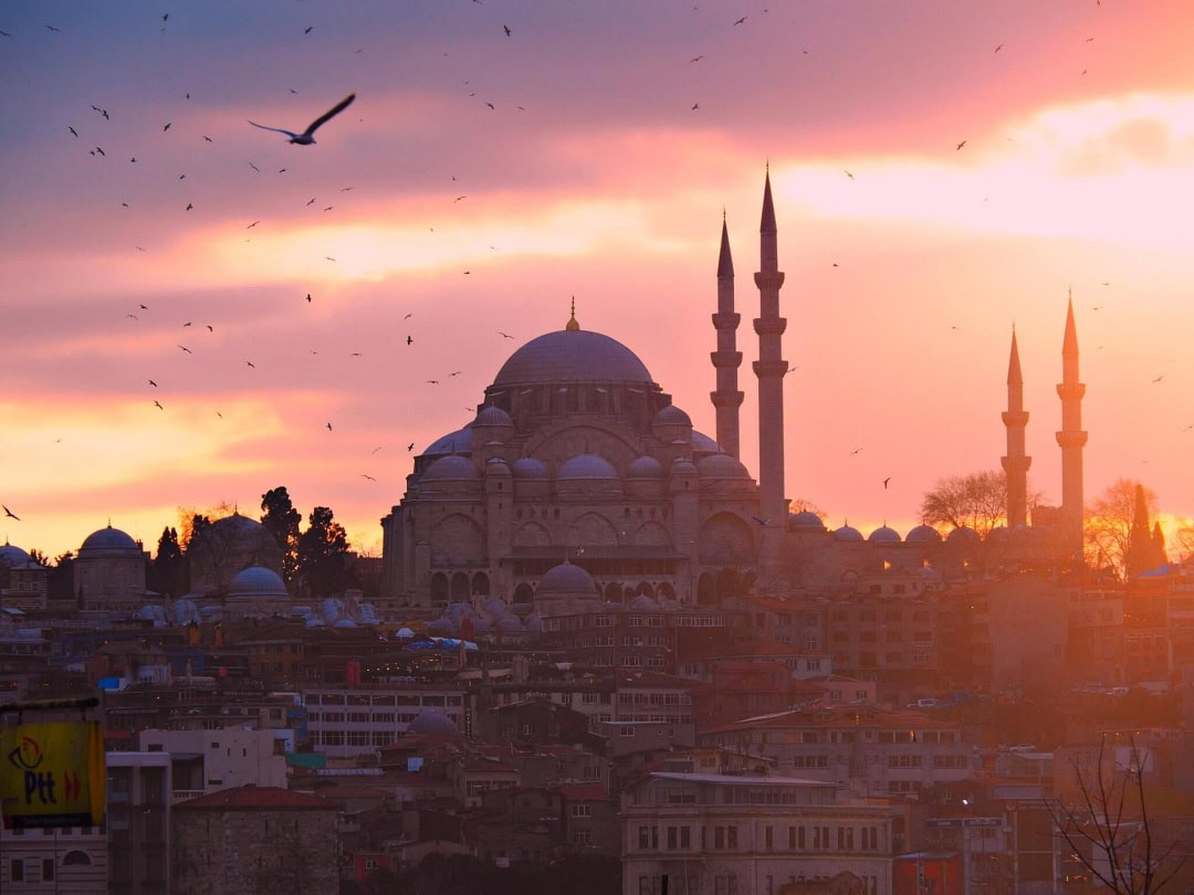 A mosque in Istanbul's Eminonu area at sunset, as seen from the Galata Bridge in Turkey