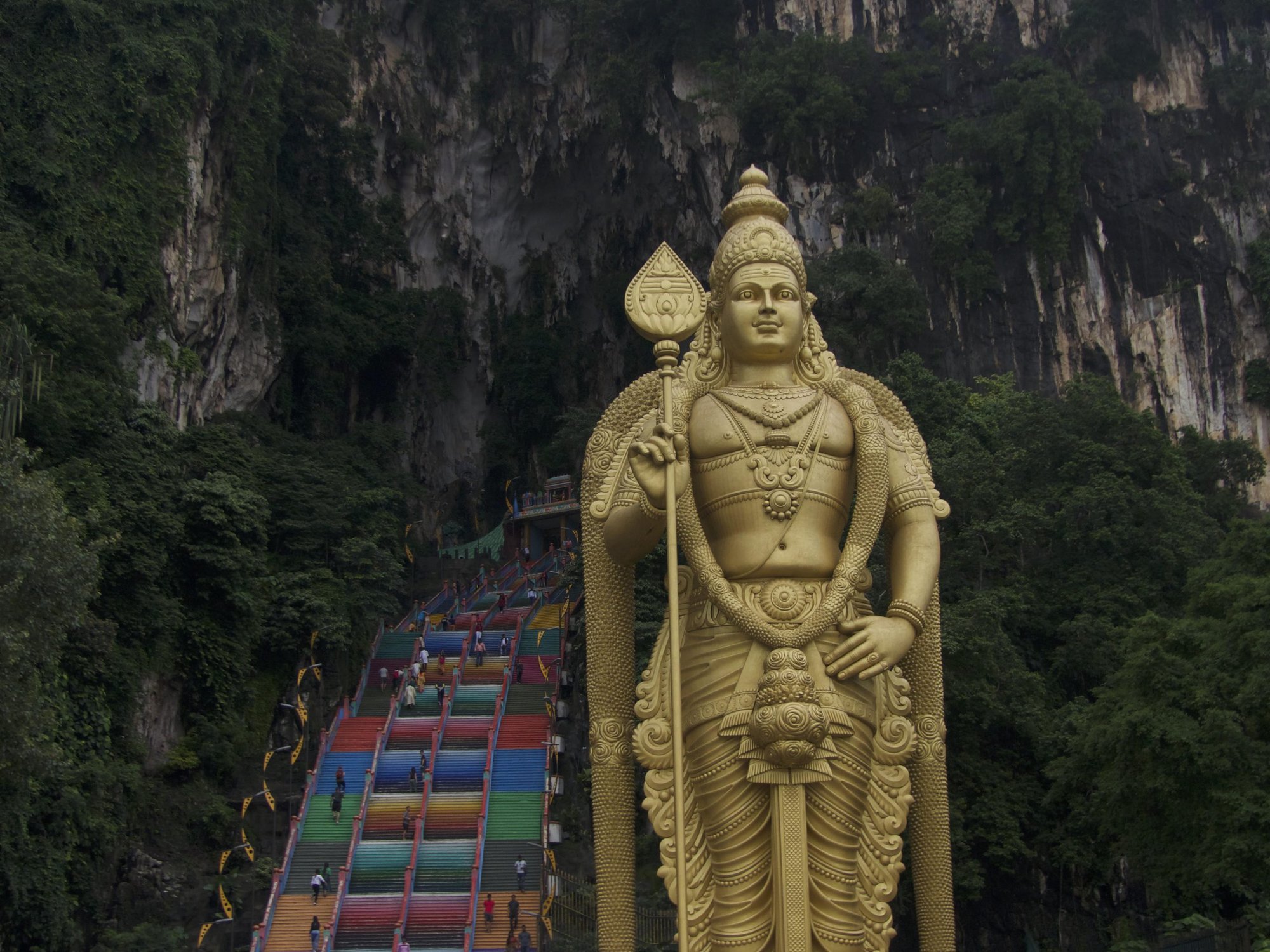 batu cave entrance with colourful steps and golden buddha in Malaysia