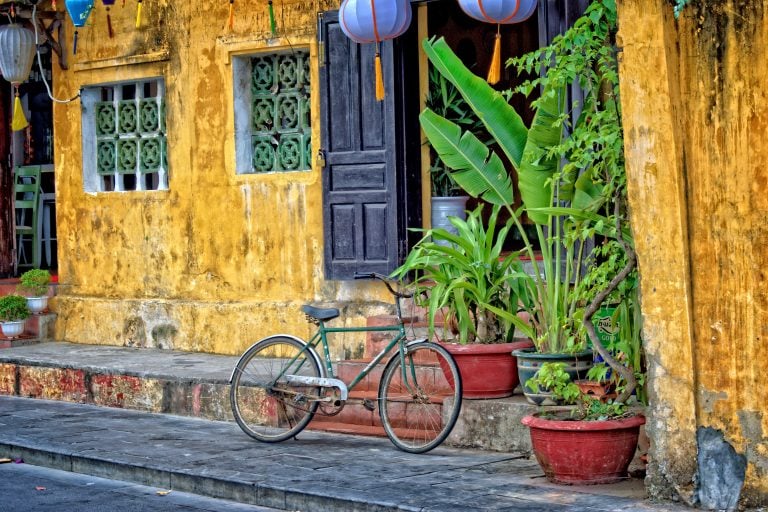 a traditional yellow house in hoi an vietnam with a bike out the front