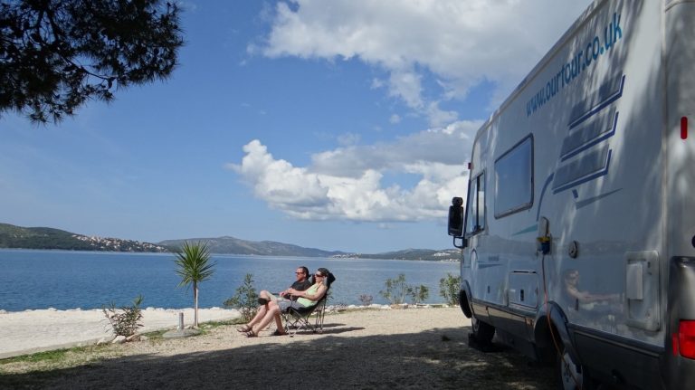 a couple sitting in chairs and Relaxing outside our motorhome in Croatia