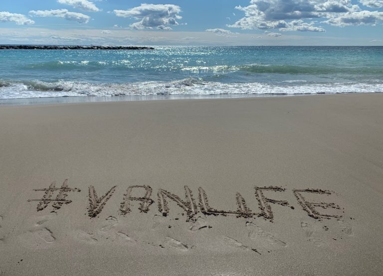the words #van life written in the sand at the beach