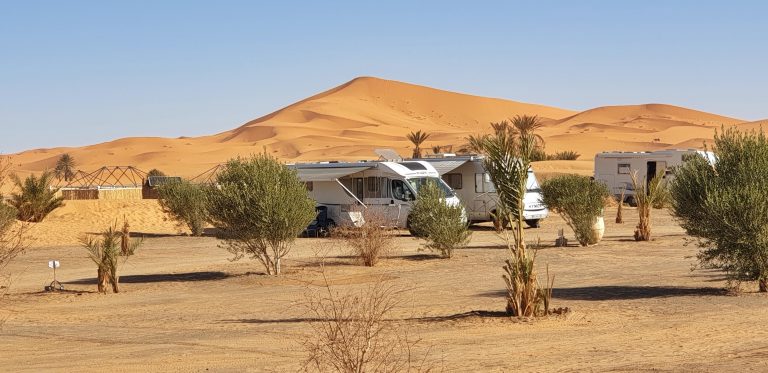 motorhomes parked amongst sand dunes in a desert