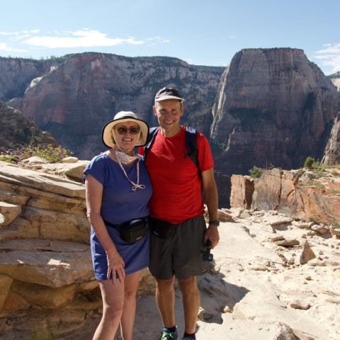 a couple standing in front of a rock formation