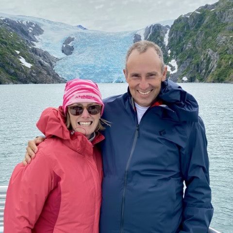 a couple standing with a glacier in the background