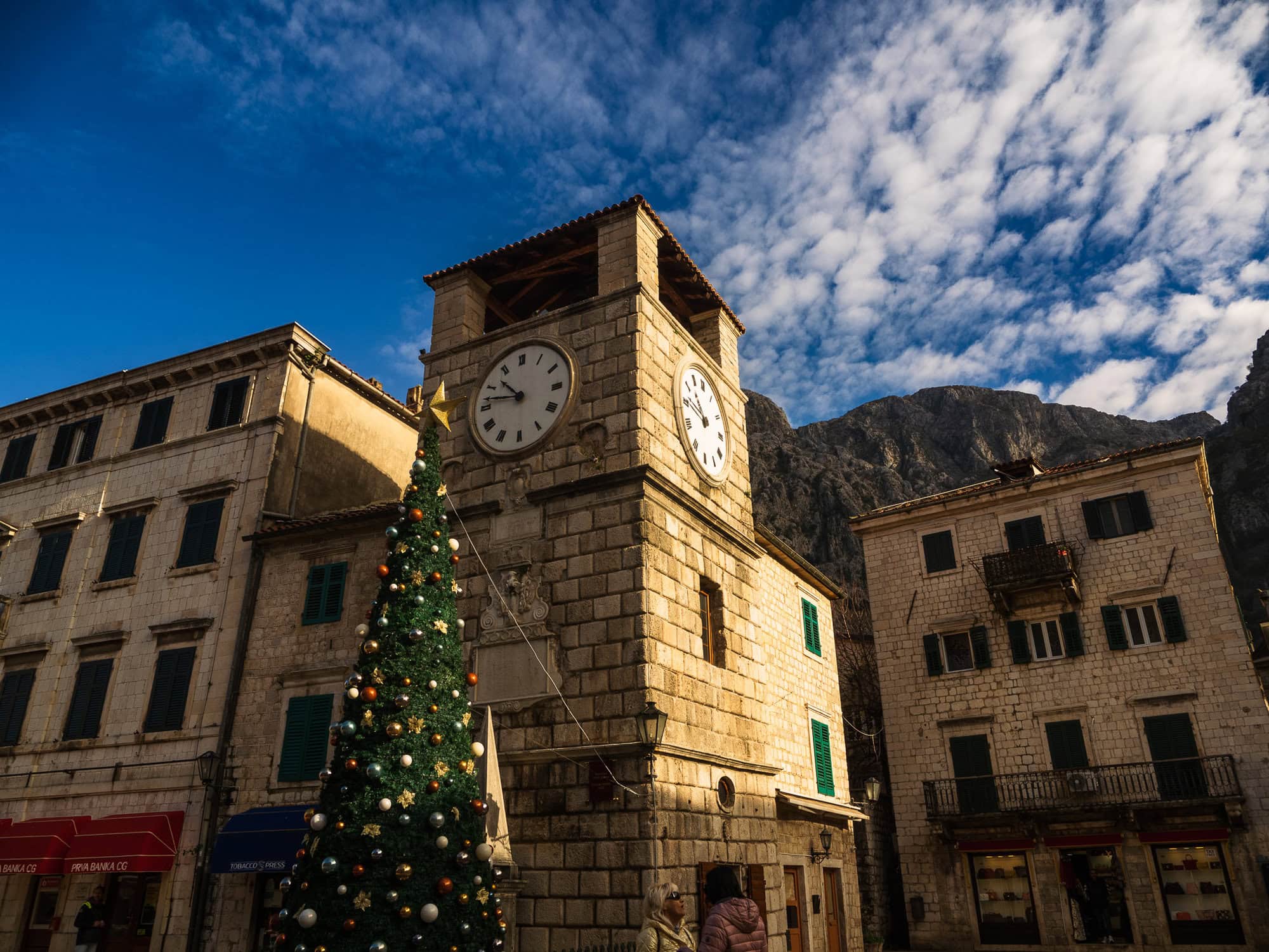 photo of clock tower with a large xmas tree beside it