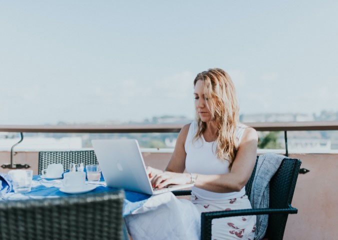 lady on a laptop in front of a city view