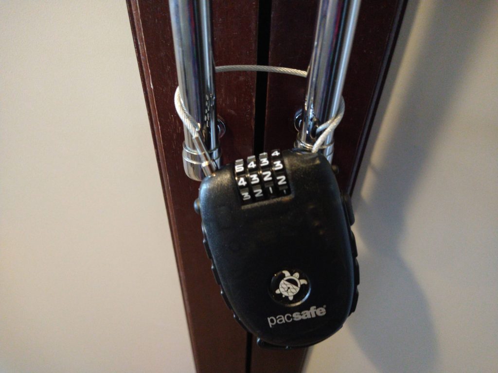4 dial retractable cable lock being used to secure the handles on a cupboard