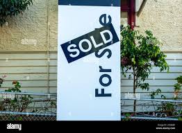 for sale sign for a house with a sold sticker across it