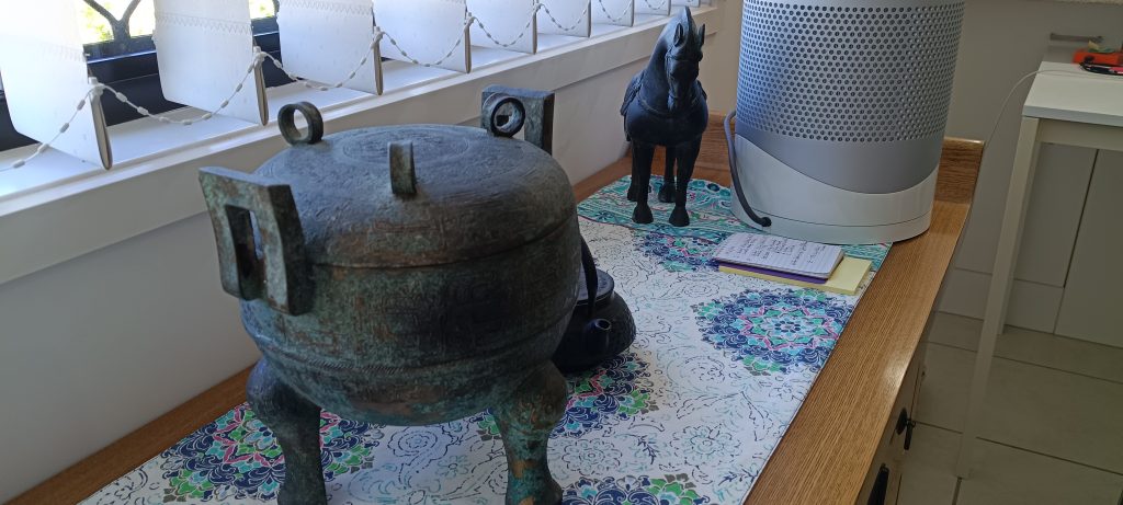 Vintage decorative items on a wooden sideboard, including sculptures and ornaments, representing belongings evaluated during downsizing.