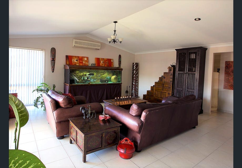 Fully furnished living room with leather couches, large aquarium, and wooden cabinetry before downsizing to begin a nomadic travel lifestyle.