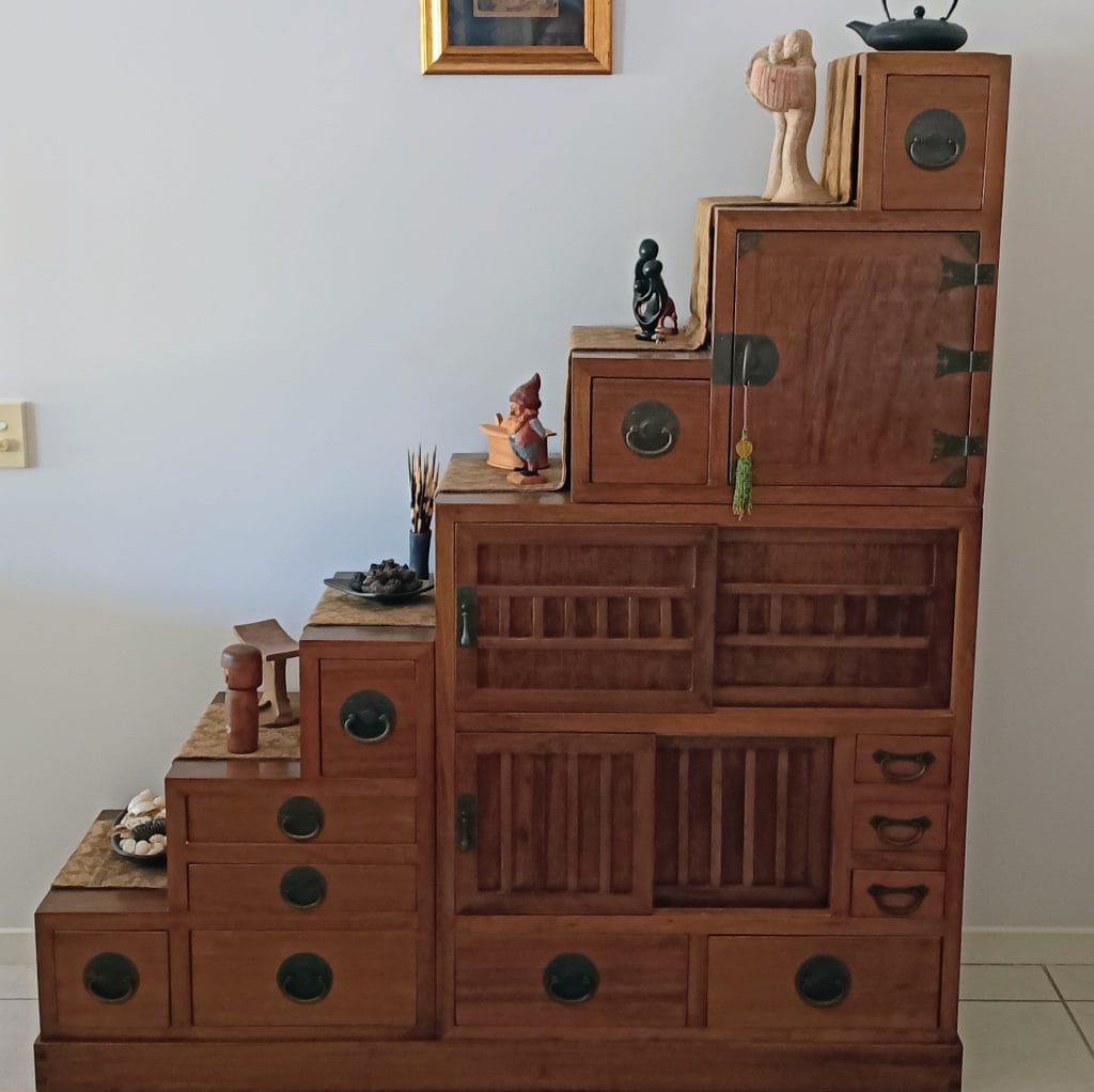 Traditional Japanese step tansu cabinet with drawers and decorative items, representing sentimental belongings considered during downsizing.