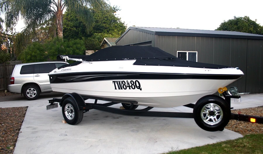 Speedboat on a trailer parked in a driveway, representing one of the major assets sold before transitioning to full-time travel.