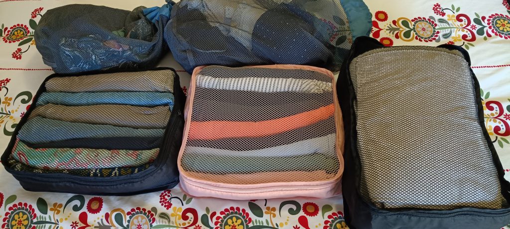 Packing cubes filled with clothing showing how to organise for long term travel