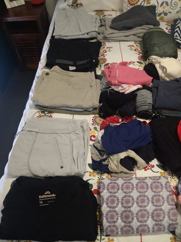 Final clothing selection laid out using capsule wardrobe for long term travel