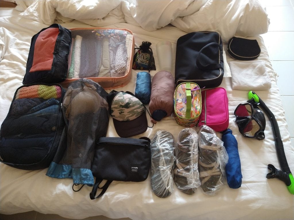 Travel gear and packing cubes laid out neatly demonstrating how to pack for long term travel