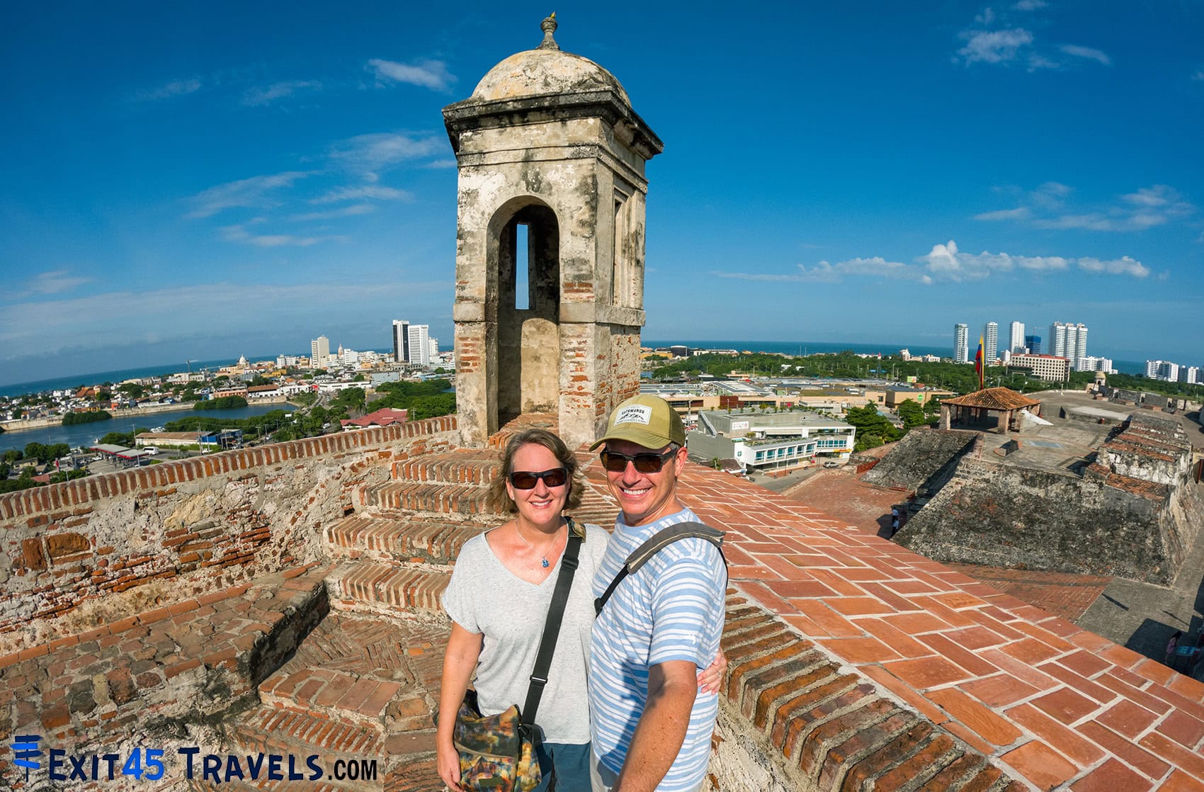 Couple standing on historic walls overlooking Cartagena city and coastline in Colombia