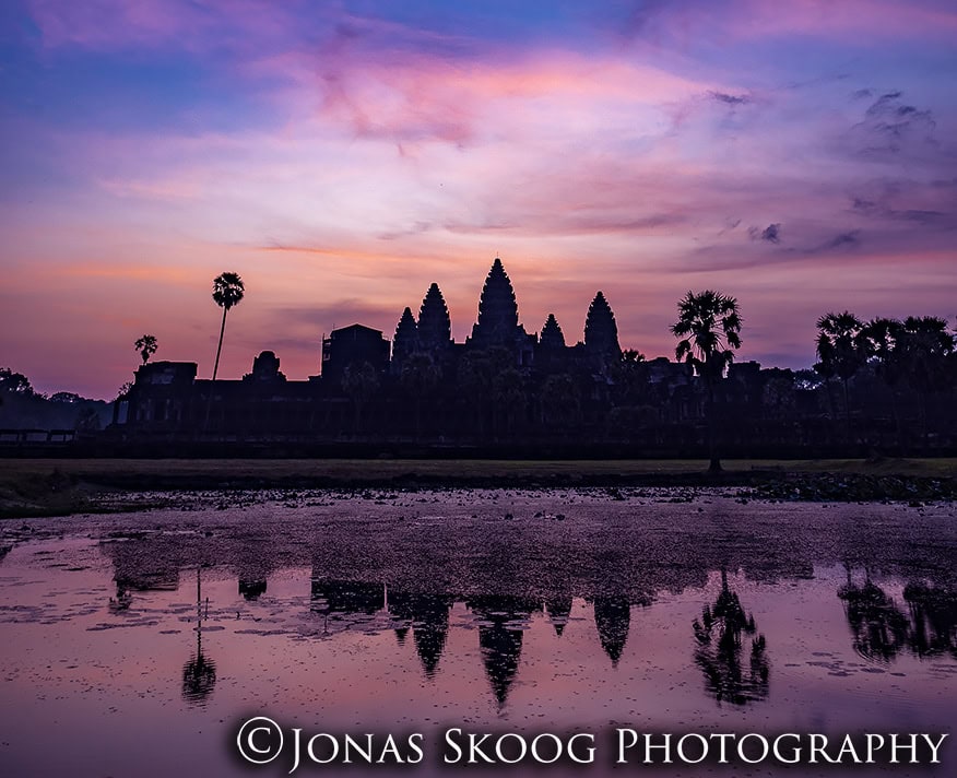 Sunrise over Angkor Wat temple in Cambodia reflecting in water with colorful sky