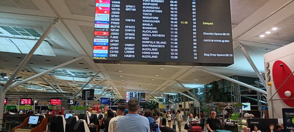 Airport departure board and crowds showing the reality of travel days during full-time travel