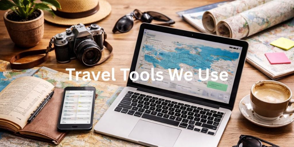 Travel planning workspace with laptop, maps, camera, notebook and coffee showing tools used for organising trips