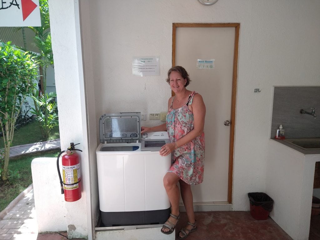 Woman using an outdoor washing machine while travelling in Bohol