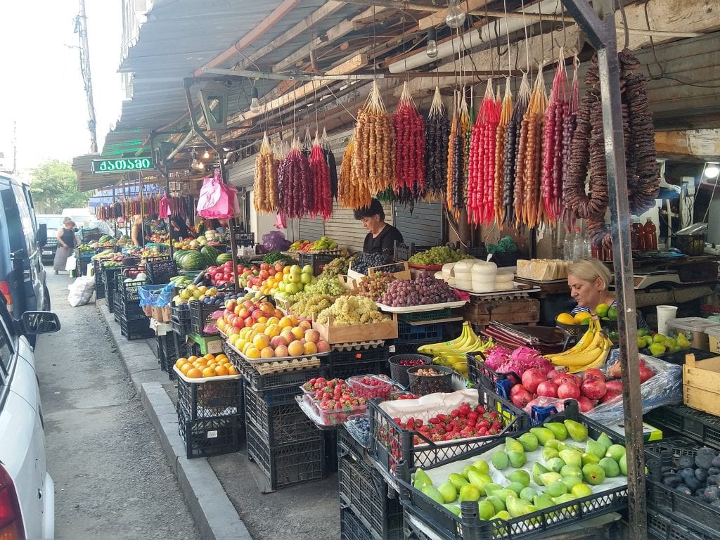 Local market stall with fresh fruit and produce in a busy street setting