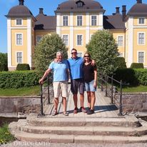 Three people standing outside a historic building while visiting family