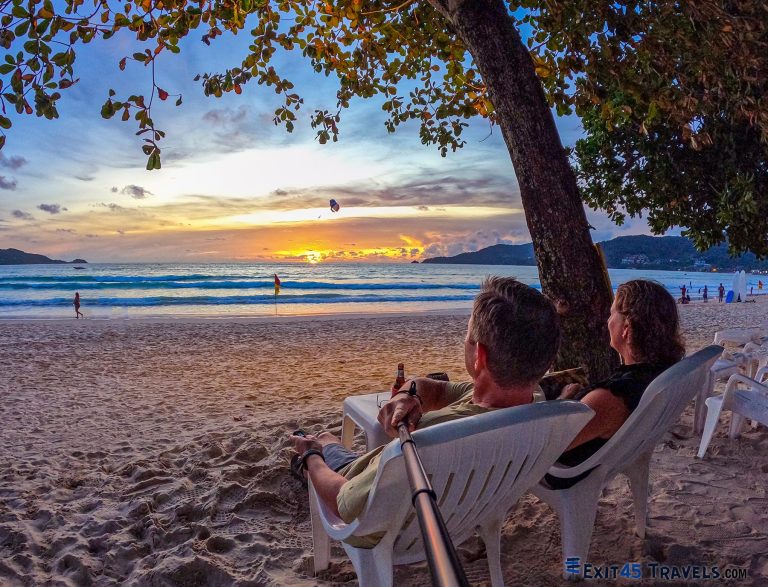 Couple enjoying sunset beach lifestyle while travelling full-time on a realistic budget