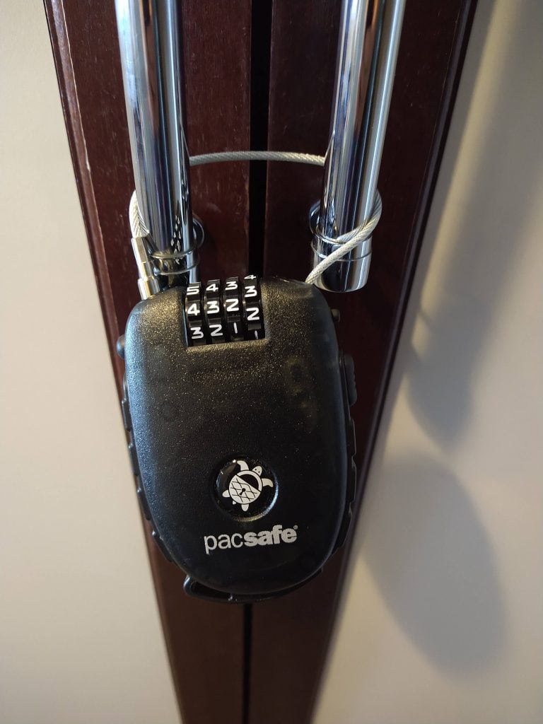 Retractable cable lock securing wardrobe handles to help keep valuables safe while travelling.
