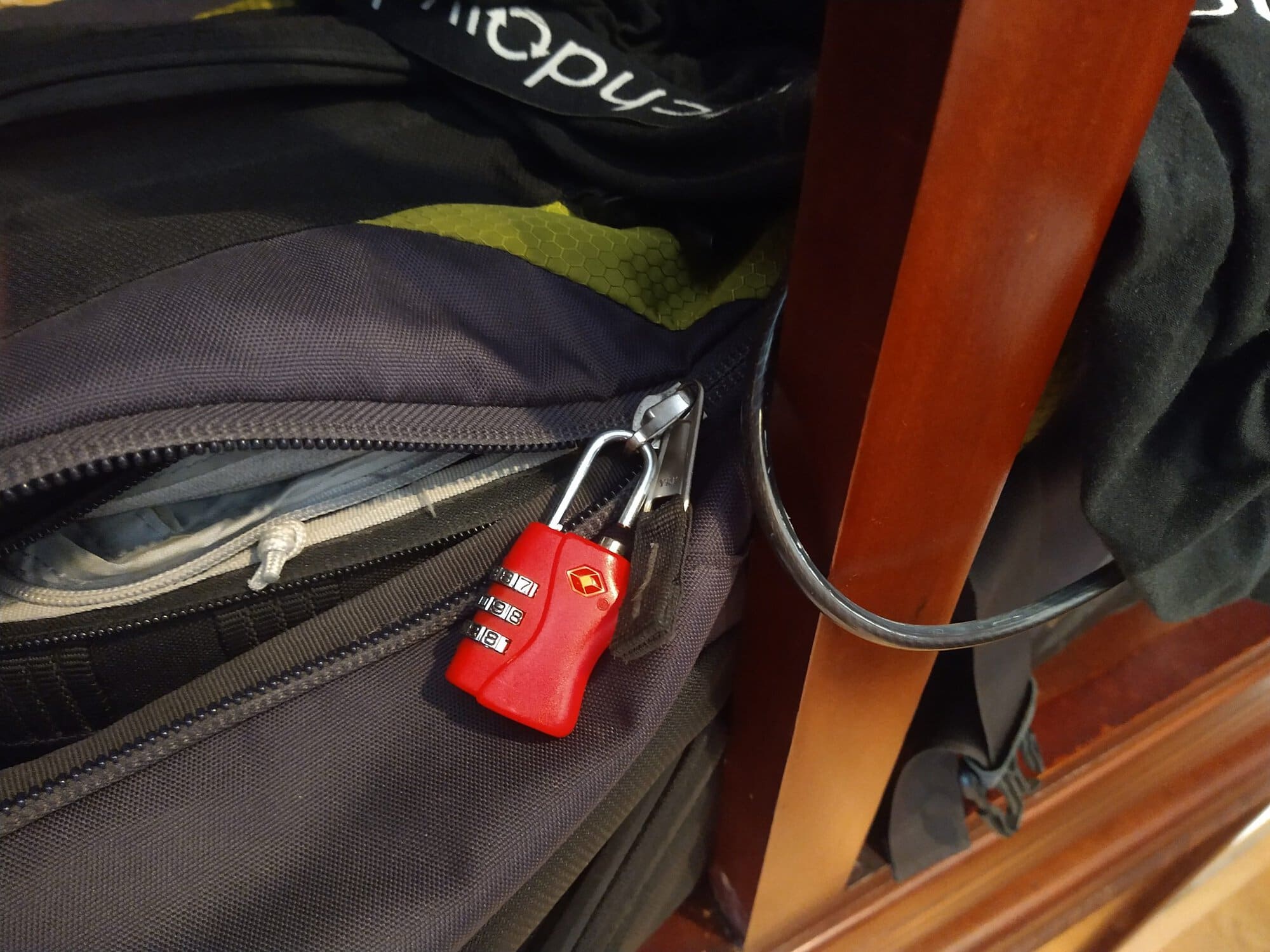 Backpack secured to furniture with a cable lock to help keep valuables safe while travelling.